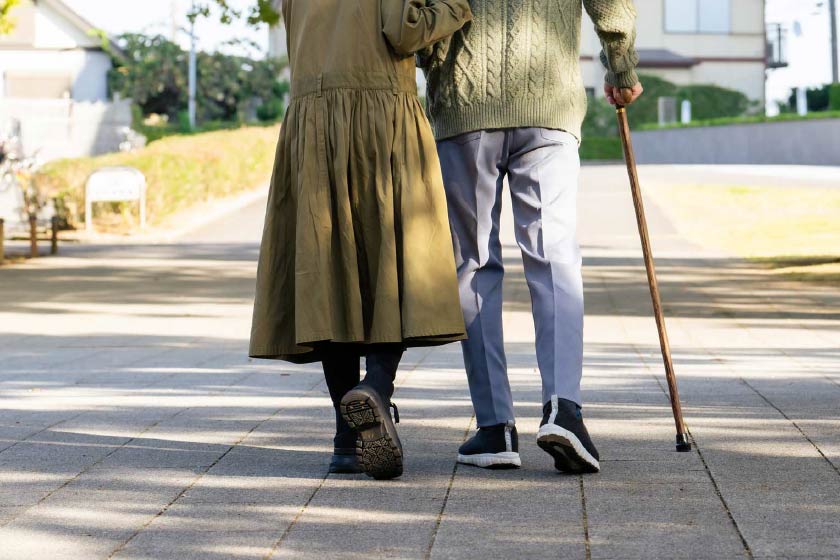 寄り添って歩く老夫婦